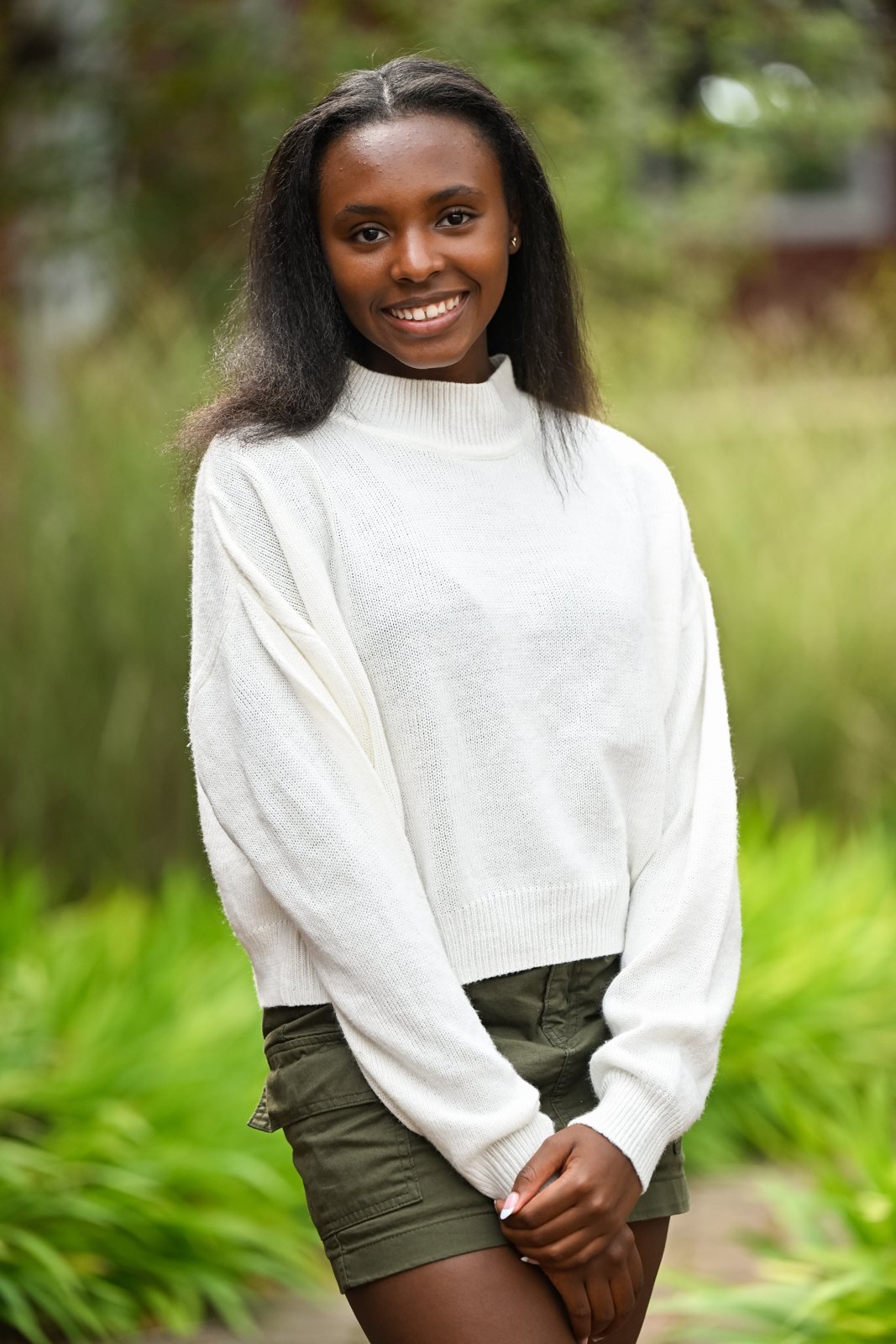 Laila outdoors in a white sweater